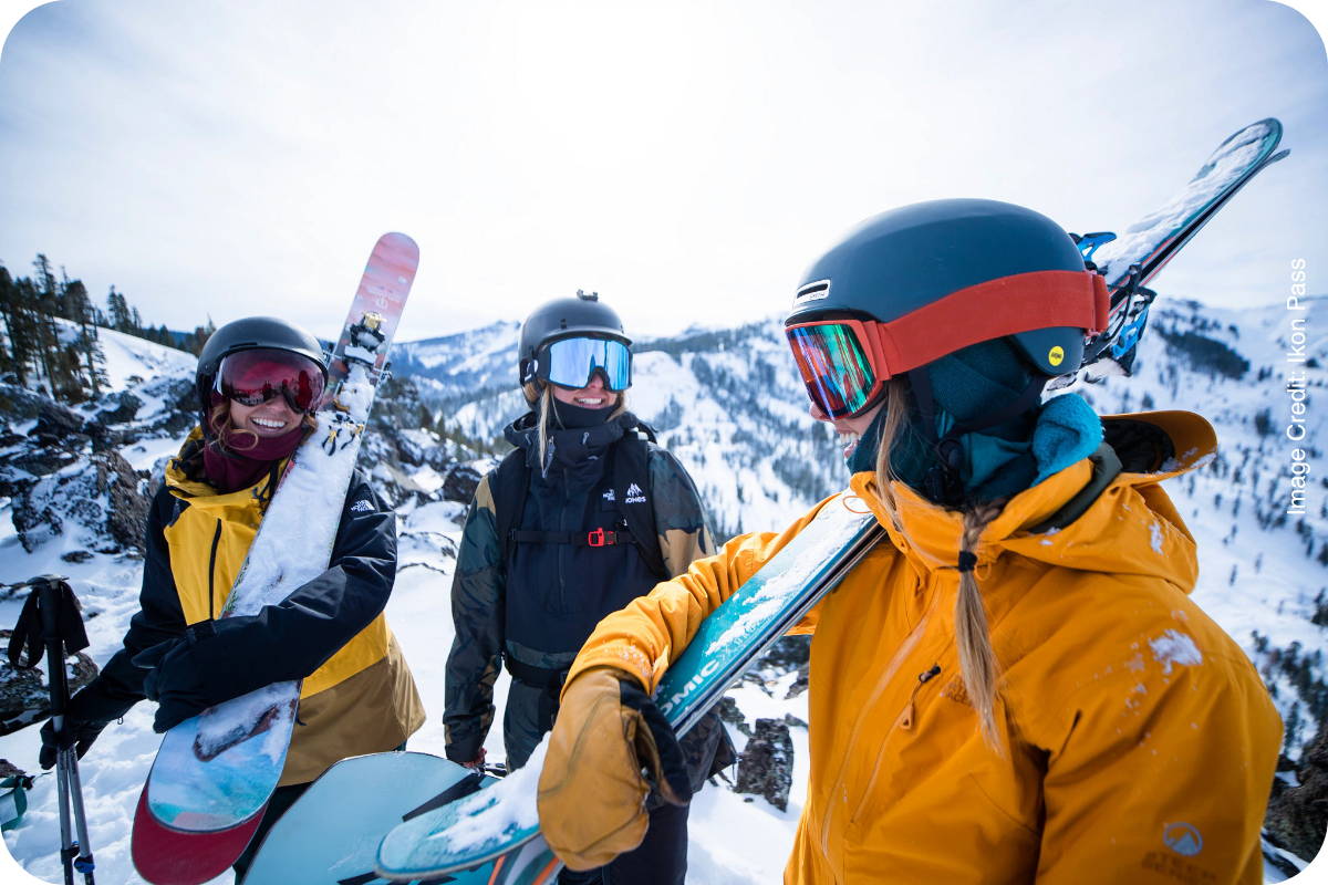Skiers in helmets and goggles smiling on the mountain