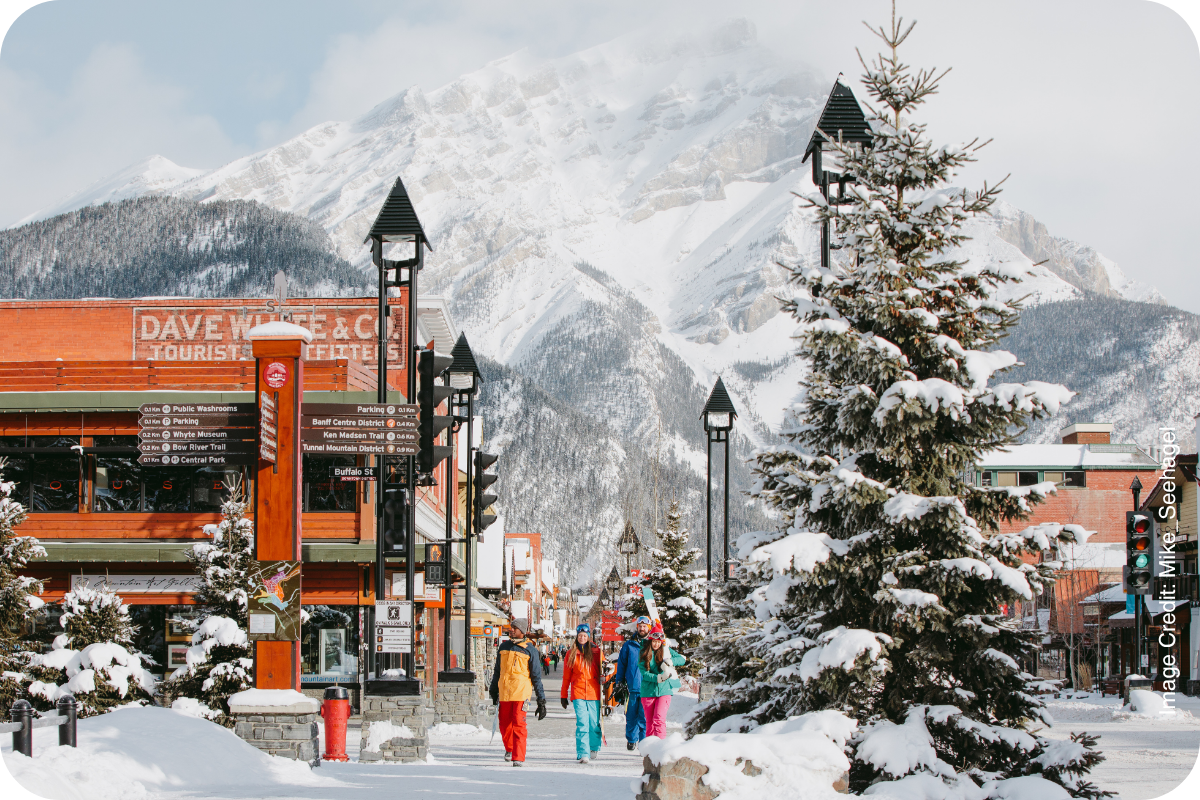 Snowy Banff street with a Christmas tree and the Rockies behind
