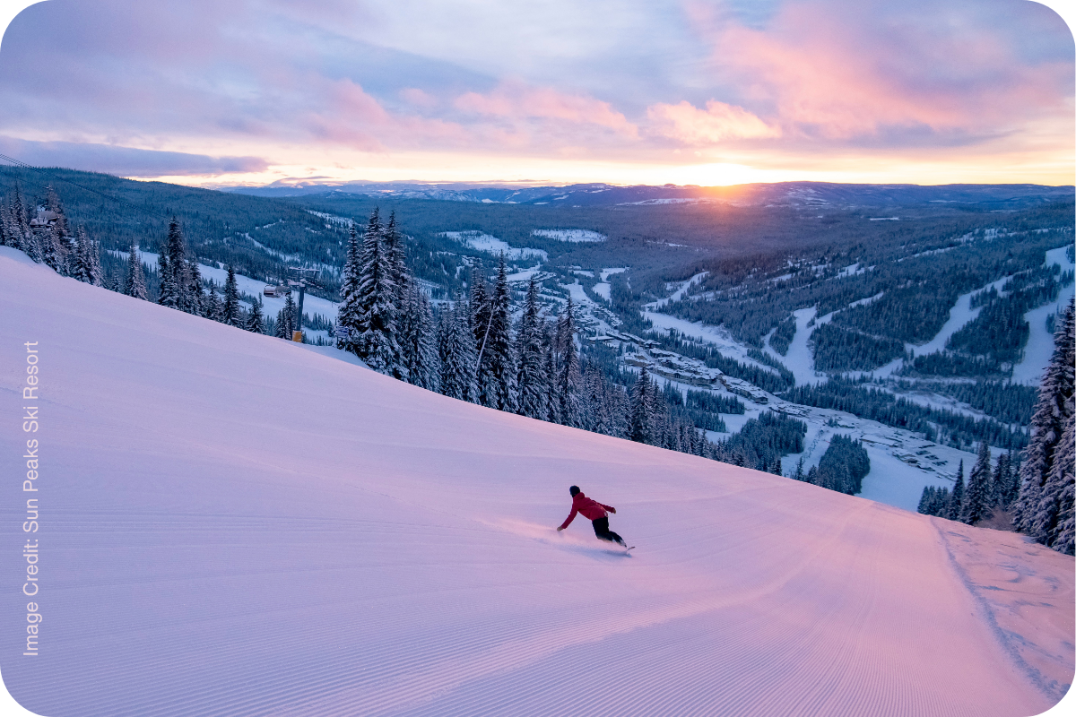Skier on a groomed run at sunset at Sun Peaks